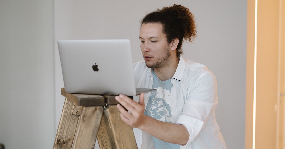 What does ISAC stand for? - A Man Using a Laptop on a Wooden Stand
