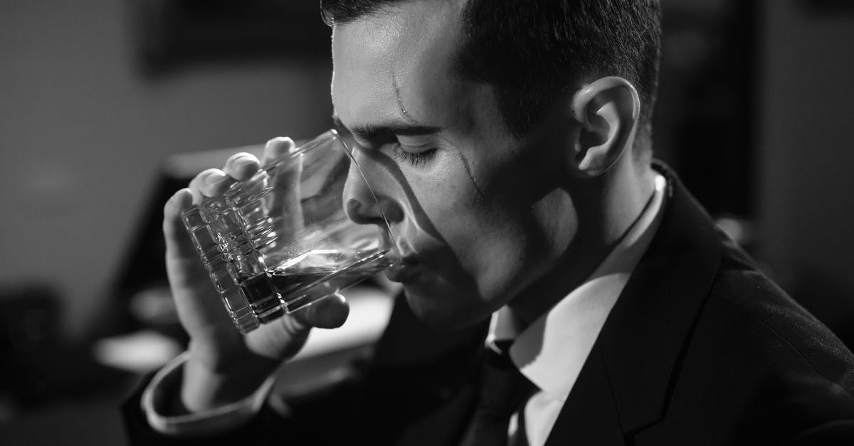 What does suspicious behaviour mean? - Close-Up Photo of Man Drinking Whiskey