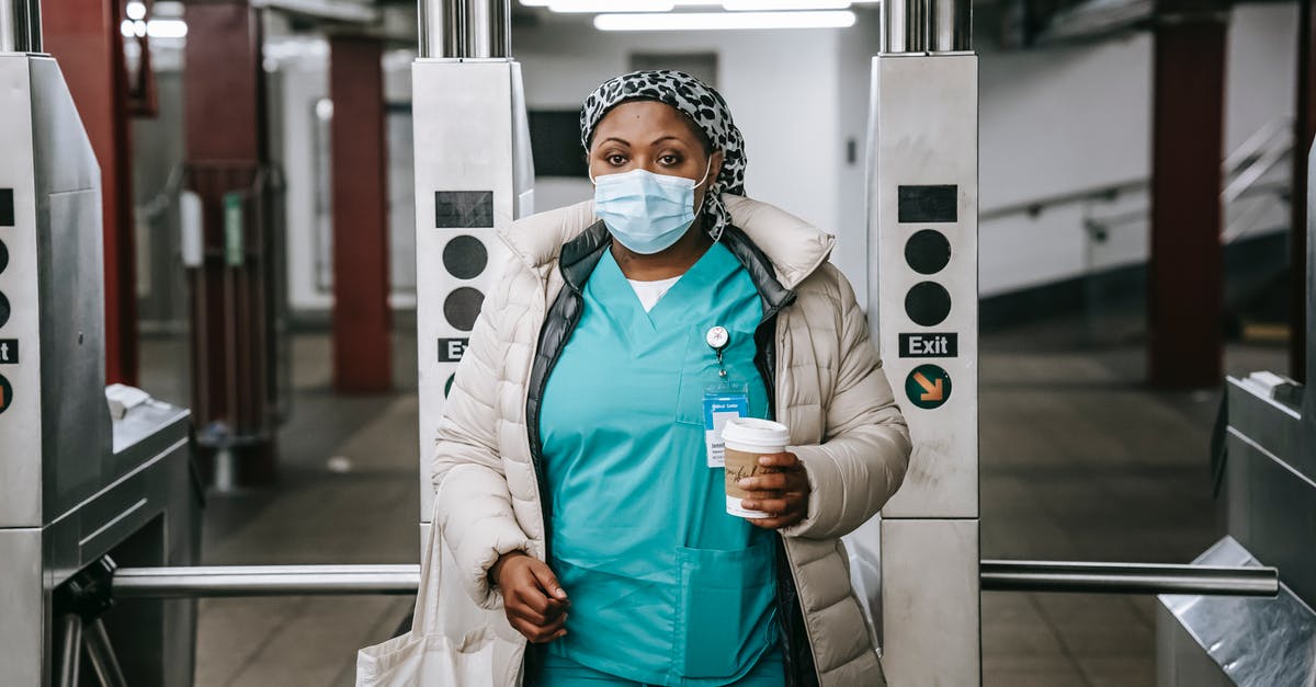 What does the season pass include? - Calm adult African American nurse with coffee to go wearing warm outfit and protective face mask passing through turnstile in metro station and looking at camera