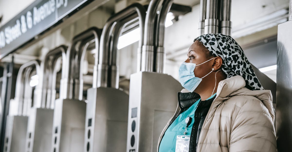 What does the season pass include? - Side view emotionless African American female doctor wearing warm clothes and protective face mask passing through turnstile gates in New York underground