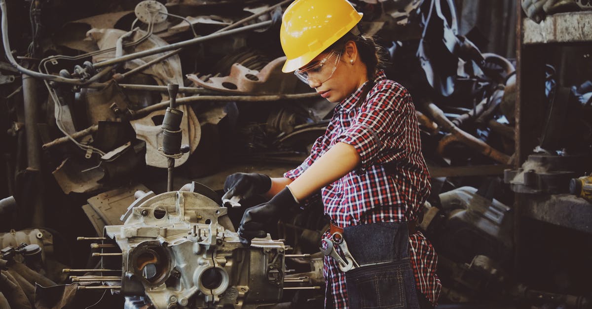 What does the SOS mechanic do? - Woman Wears Yellow Hard Hat Holding Vehicle Part