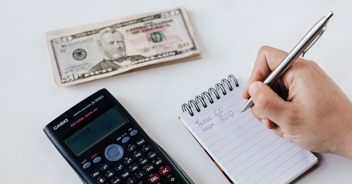 What does this hand and number represent? - Crop anonymous financier planning budget writing numbers in notebook