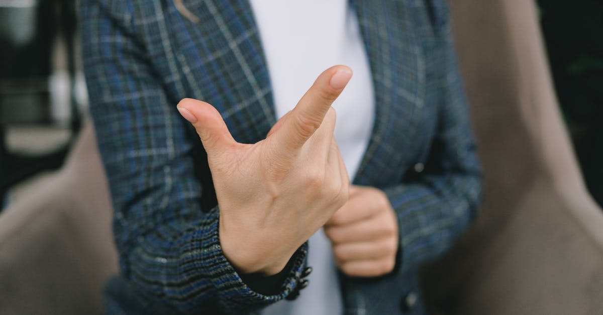 What does this symbol mean in the Starcraft chat portrait? - Crop anonymous lady in elegant blazers sitting in comfortable armchair and showing index finger while communicating using sign language