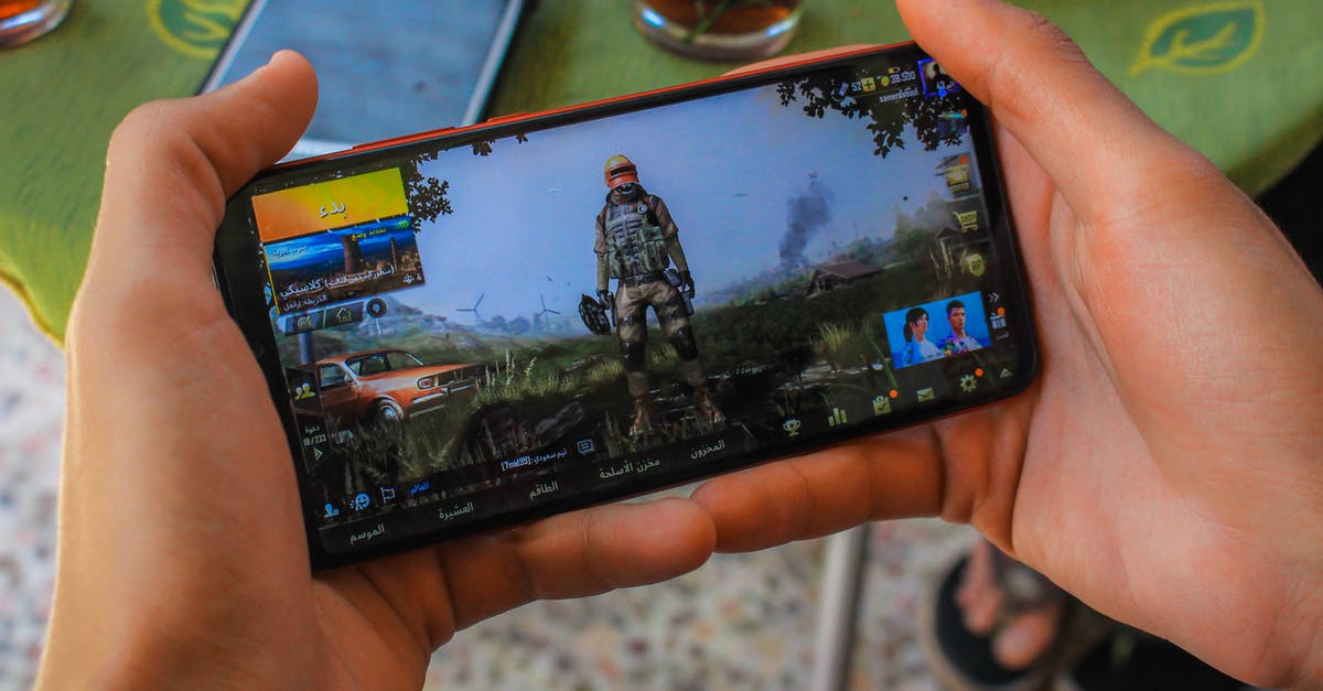 What game is this city screen from? - Crop faceless man playing video game on smartphone