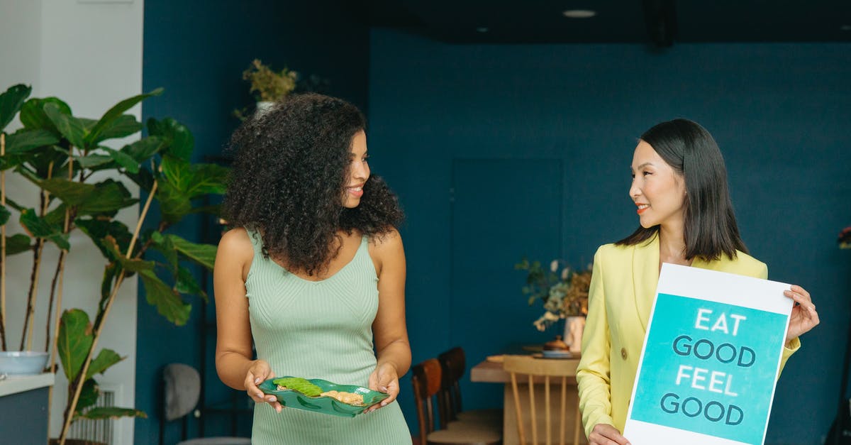 What happens if I lose all three hearts? - Woman in White Tank Top Standing Beside Woman in Green Dress