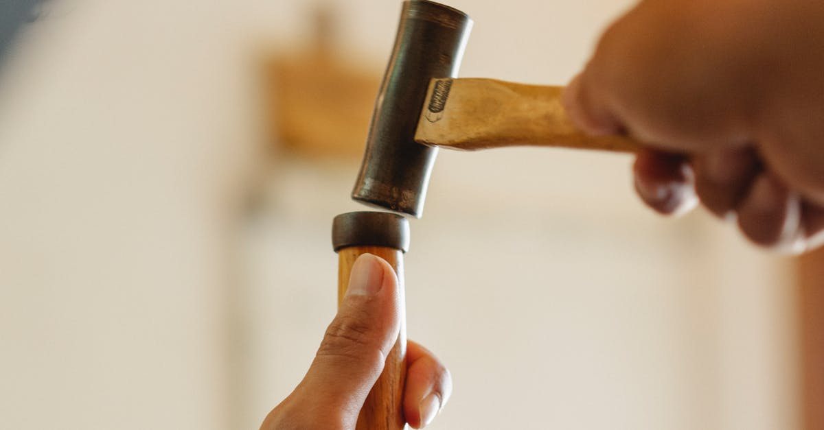 What is missing from Mario Maker for 3DS? - Low angle of crop anonymous craftsman hammering instrument while working in joinery workshop