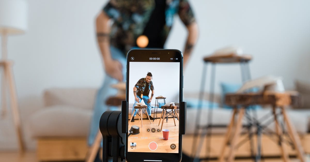 What is the Nuzlocke Challenge? - Person Holding Iphone Taking Photo of Man in Blue and White Plaid Button Up Shirt