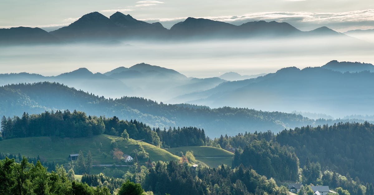 What is the range for the grenade launcher attachment? - Mountainous valley with evergreen forest against misty sky