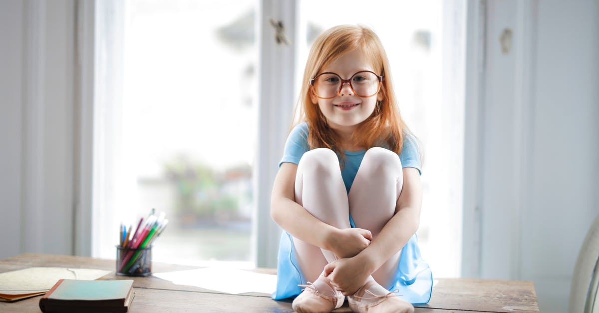 What is the Rebel equivelant of the AT-ST? - Joyful red haired schoolgirl in blue dress and ballet shoes smiling at camera while sitting on rustic wooden table hugging knees beside school supplies against big window at home