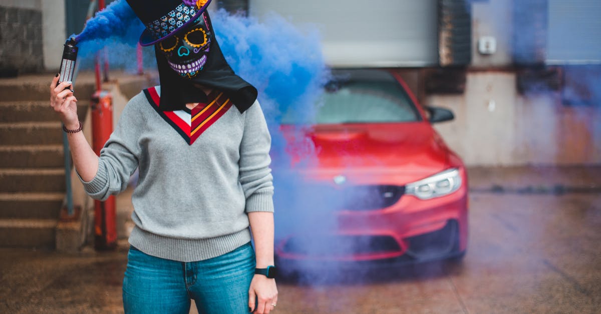 What is this blue smoke behind a wall? - Unrecognizable woman with smoking flare