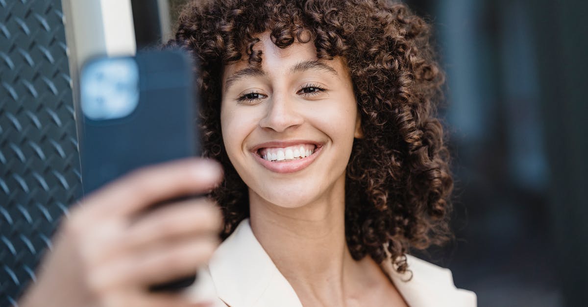 What kind of tarot is used in Persona 5? - Positive young ethnic female with curly brown hair taking self shot on cellphone in town on blurred background