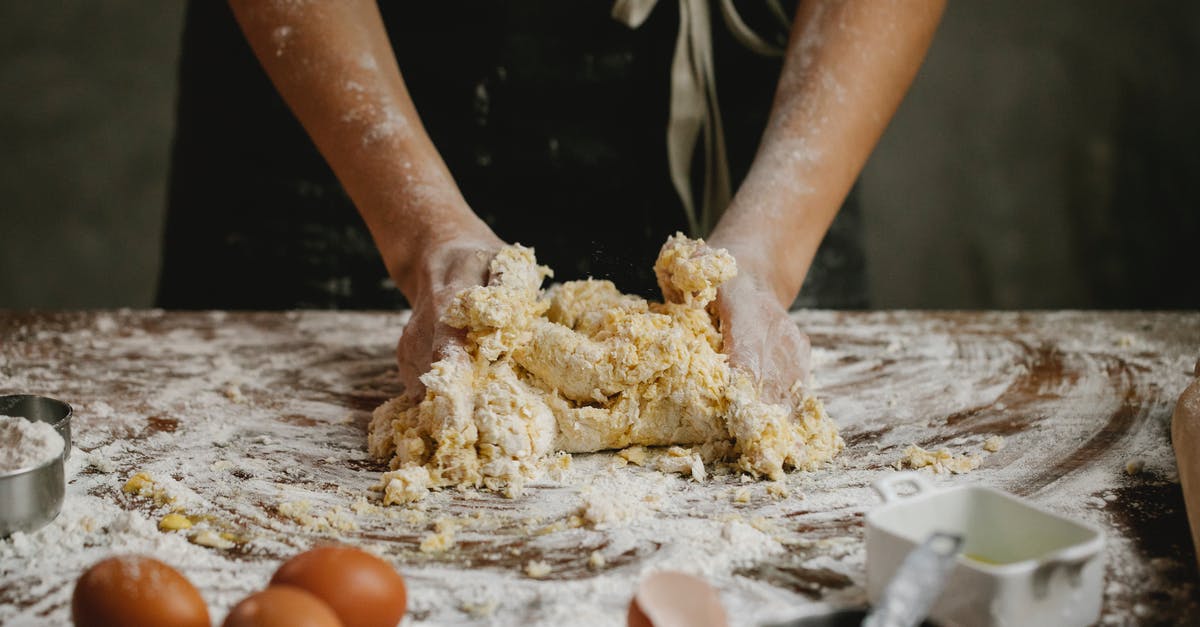 What makes surfaces portal-able? - Unrecognizable person preparing dough while standing at table with eggs covered with flour in kitchen during cooking process at home