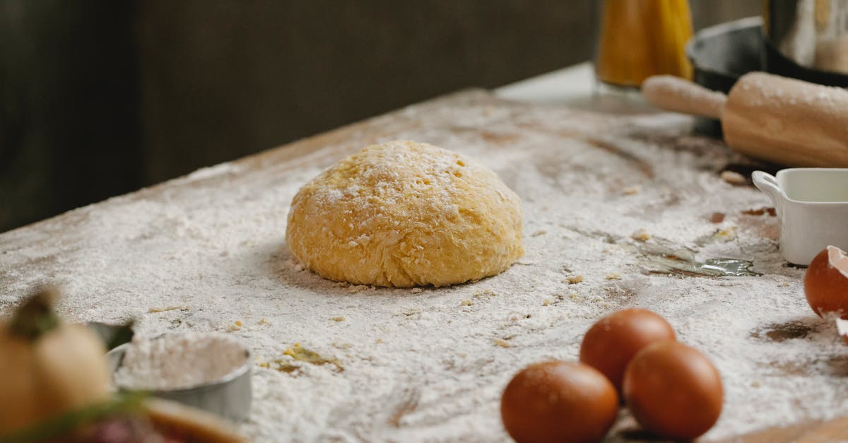 What makes surfaces portal-able? - From above of raw dough placed on table covered with flour near kitchen utensils and eggs in kitchen with ingredients