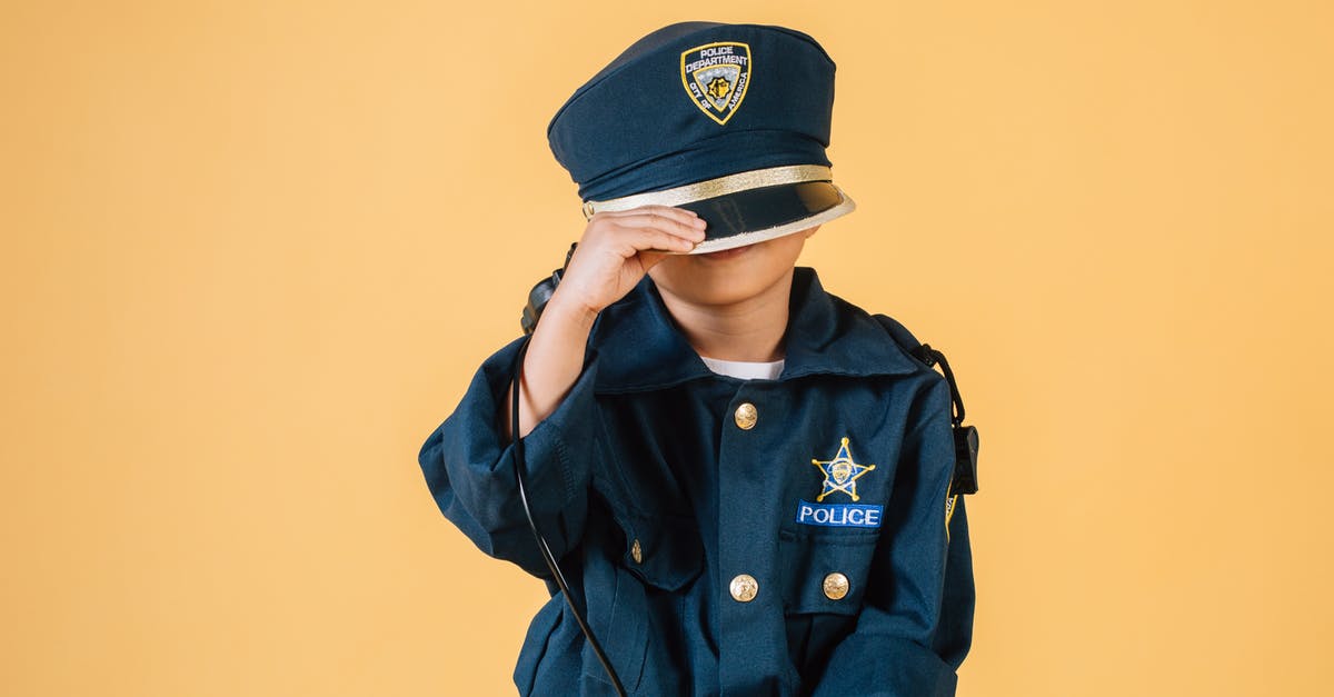 What order should I play the Half-life series in? - Unrecognizable child in police uniform standing in studio with transceiver in hand and pulling cap over face on yellow background