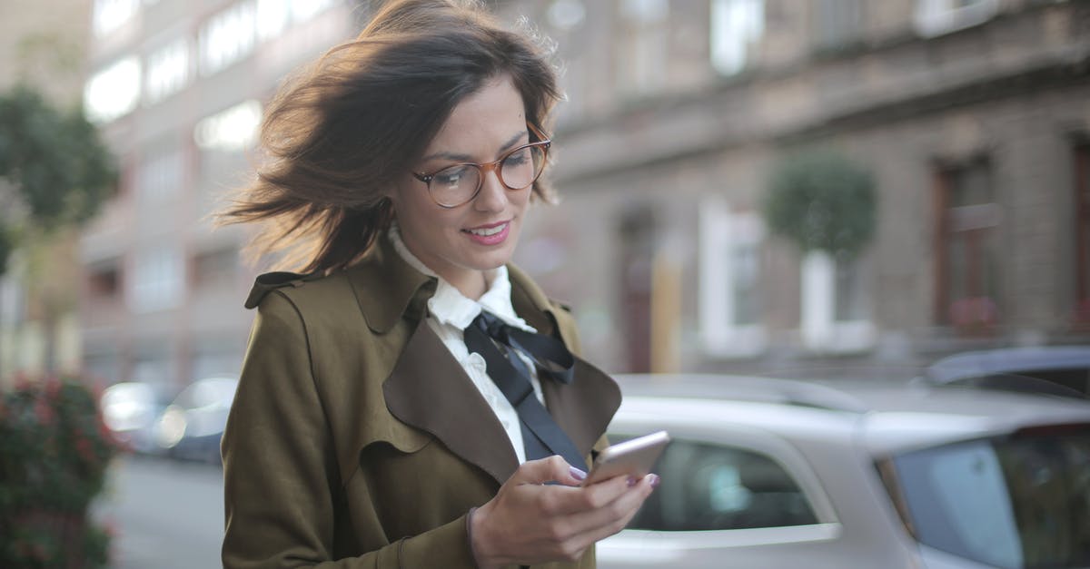 What use are sensors to an explorer? - Stylish adult female using smartphone on street