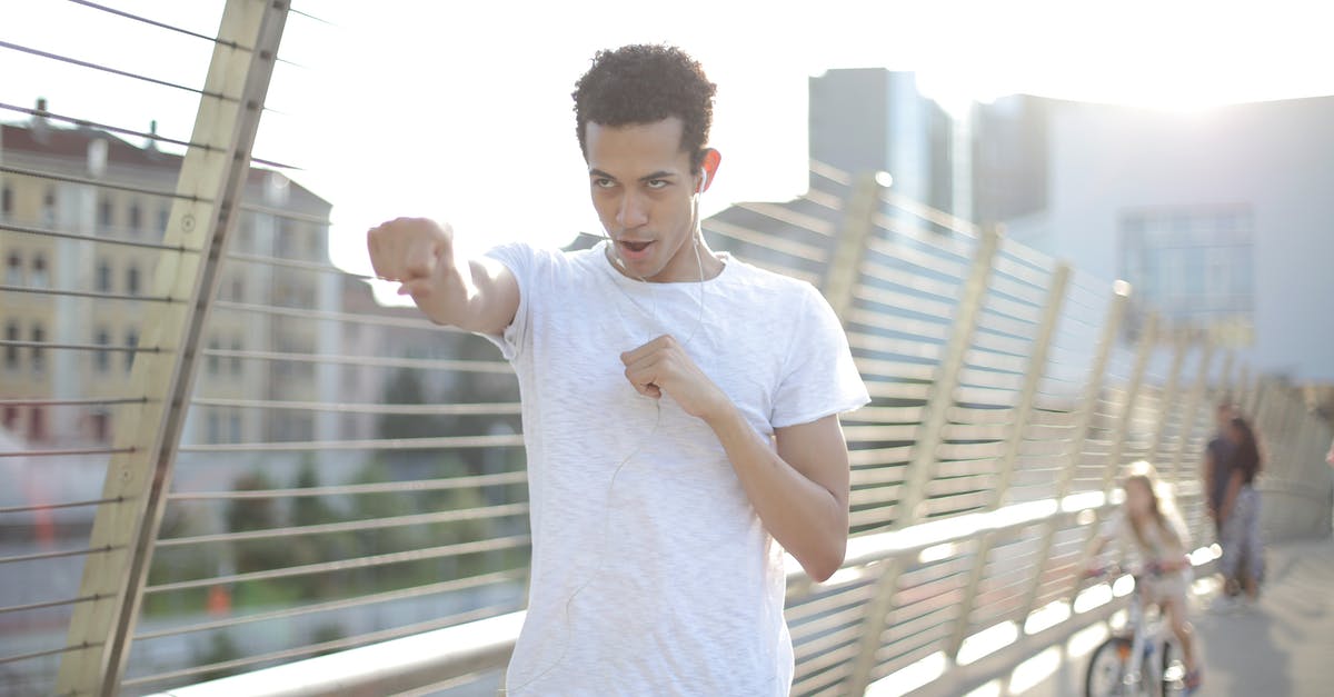 When is the 300 hit window? - Low angle of positive confident African American male athlete with mouth opened in earphones and sports clothes looking away and doing kick gesture while warming up before training on street against blurred urban environment in sunny day