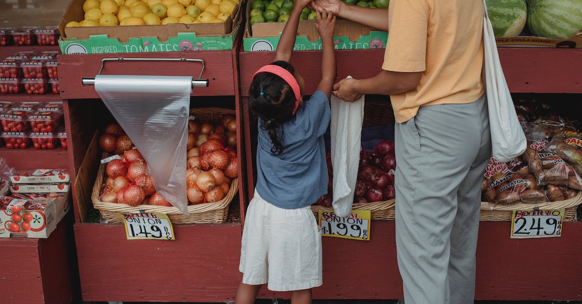 Where are RCT2 save files stored? - Ethnic woman choosing fruits with daughter in market