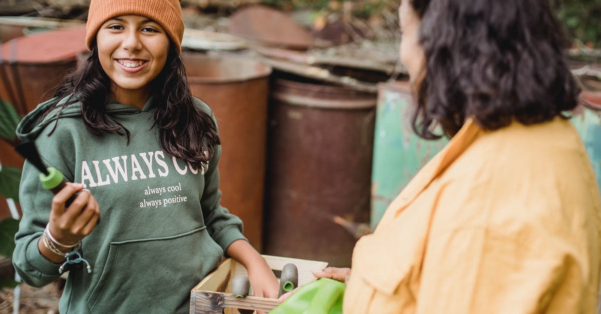 Where can I farm Titanite shards? - Happy ethnic girl with gardening tool and box looking at camera near crop unrecognizable mother on farm