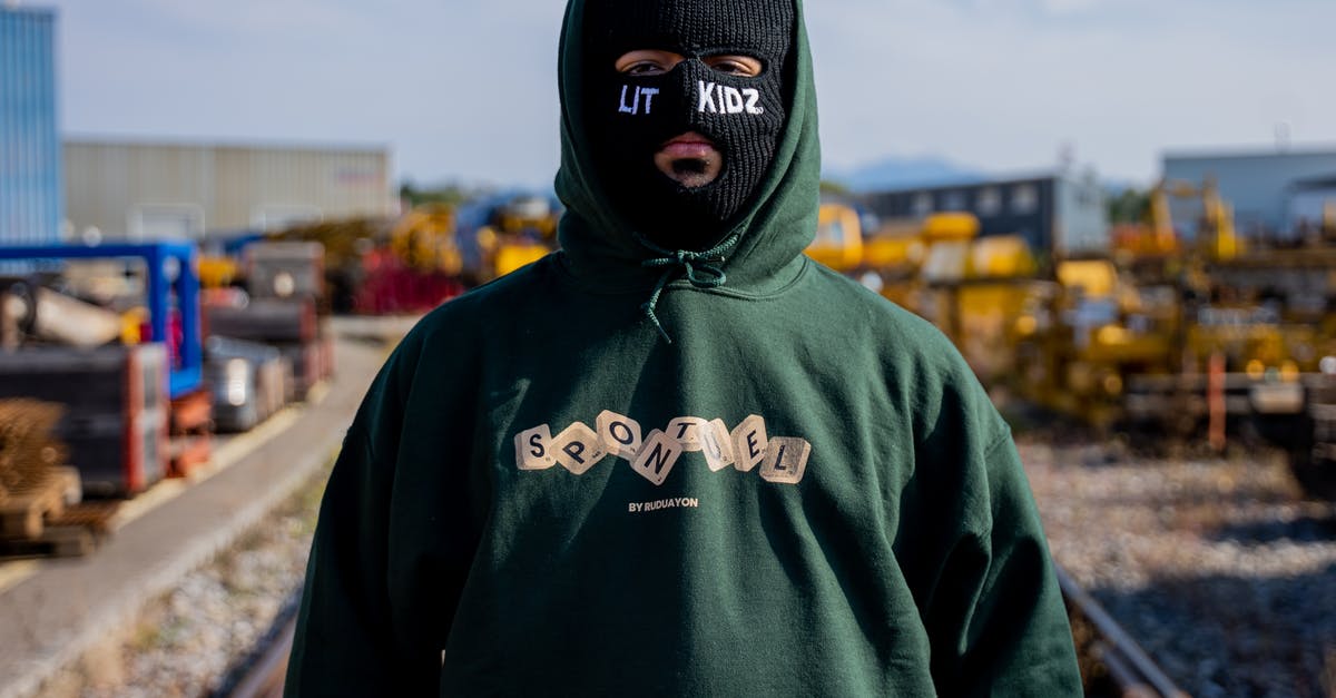 Where do you buy Elite Dangerous for Mac? [closed] - Close-Up Shot of a Person in Green Hoodie Wearing a Black Ski Mask