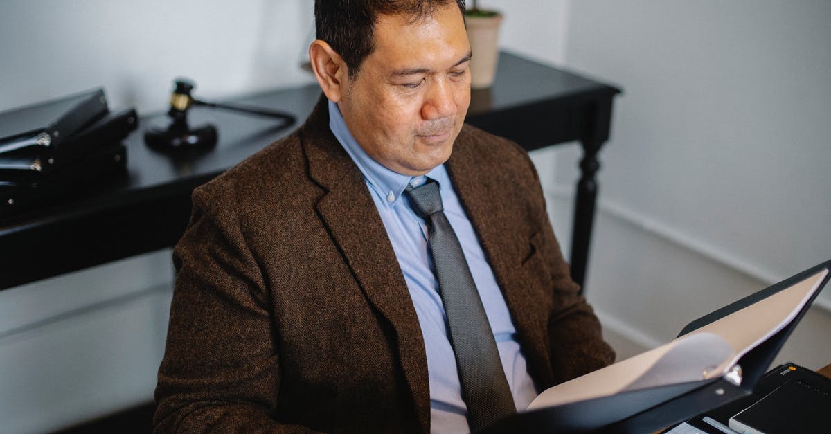 Where to get the hammer suit - Pensive Asian lawyer examining report in office