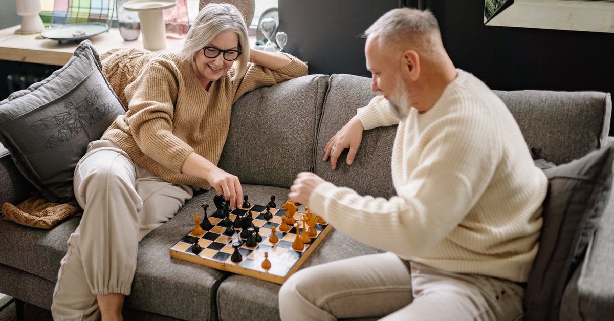 Which is the better archer? - Couple Sitting on a Couch While Playing Chess