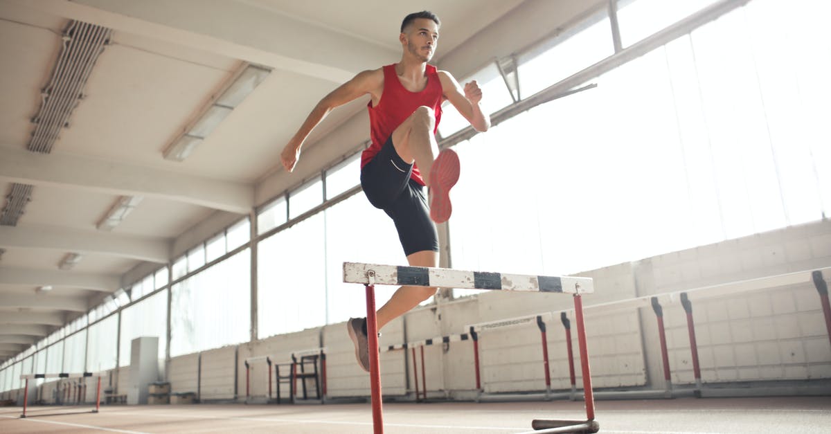 Which stat determines how fast marksman rifle re-centers? - Powerful male athlete jumping over hurdle on running track while training at sports hall