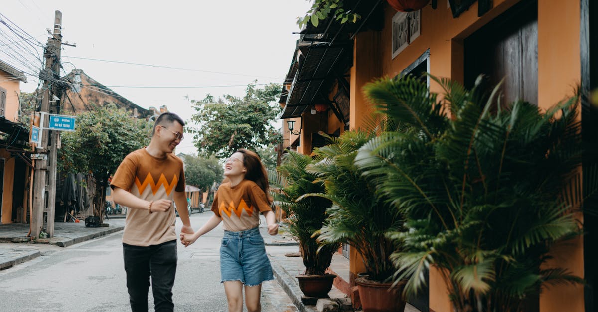 Why batches of same items are not next to each other? - Cheerful Asian couple running on street