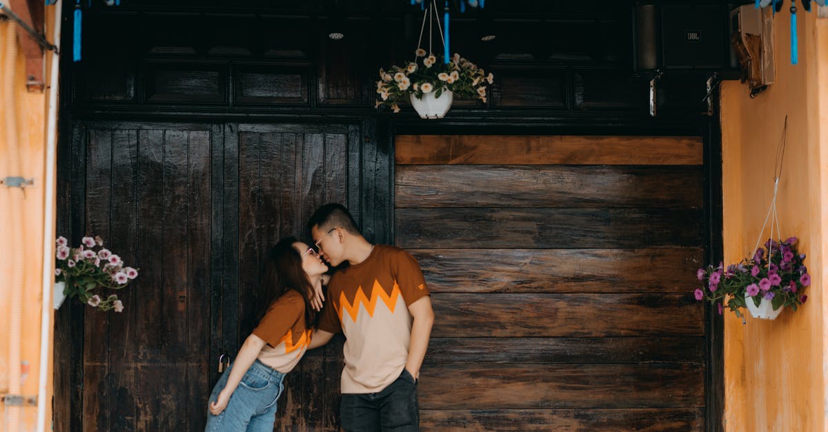 Why batches of same items are not next to each other? - Romantic Asian couple kissing near wooden wall