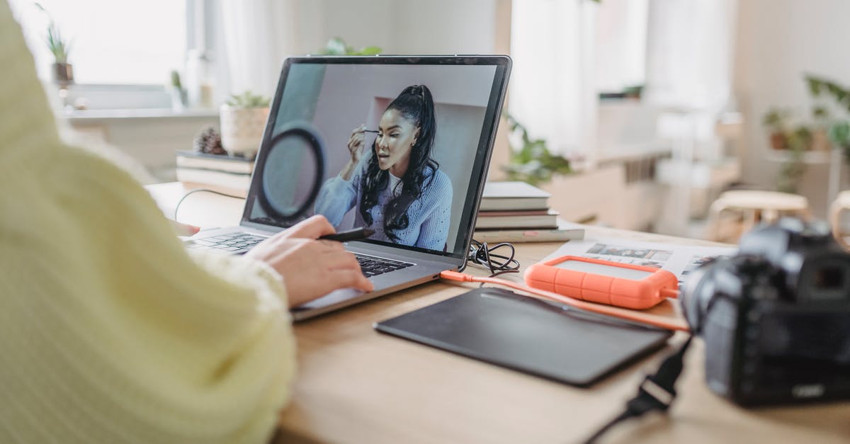 Why can't I edit or create my sim? - Crop unrecognizable female photographer editing photo while sitting at table with photo camera and graphic tablet during work in spacious room with flowerpots