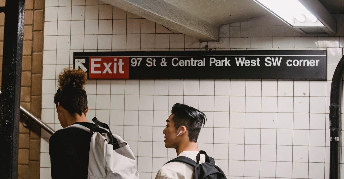 Why did my train choose the blocked path at the junction? - Back view of ethnic male walking in subway station with friend while commuting to university