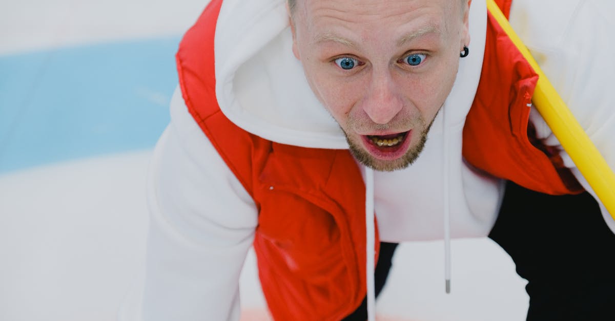 Why did the game shout DELETE IMMEDIATELY at me? - From above of thrilled male curler with broom watching stone sliding on ice sheet during curling competition