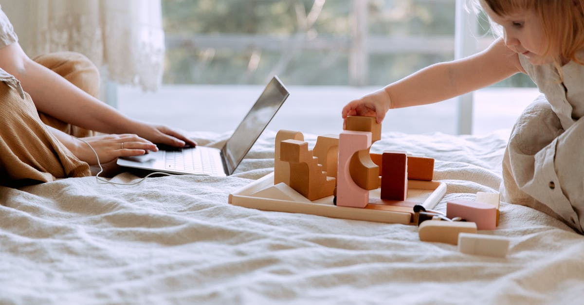 Why does execute "as" not work in Command Block - Crop mother and daughter sitting on bed while using laptop