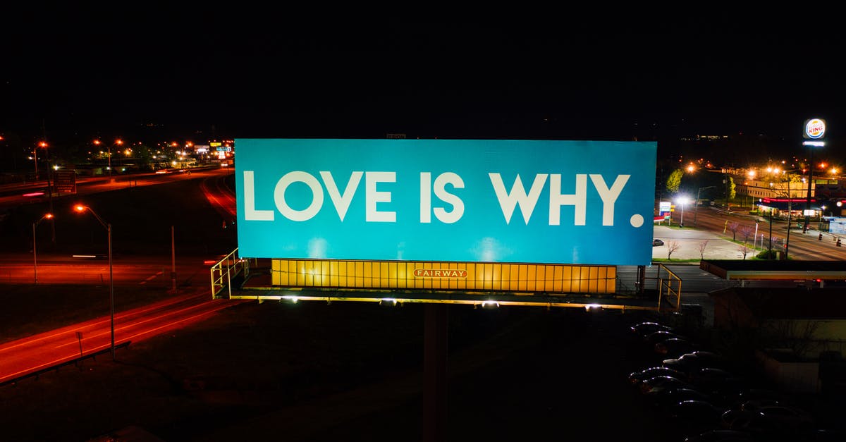 Why does Isaac glow on spiderwebs? - Blue billboard saying Love is why placed on road surrounded by cars and street lights against black night