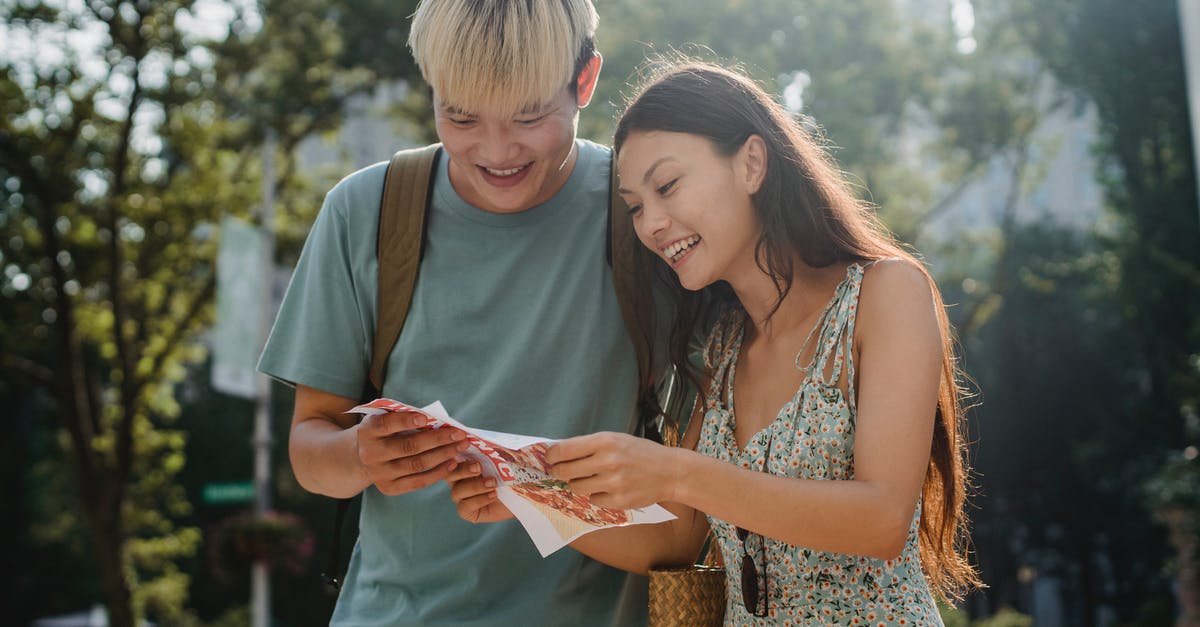 Why doesn't a downloaded map show up in Minecraft? - Cheerful multiracial couple of tourists watching map in city