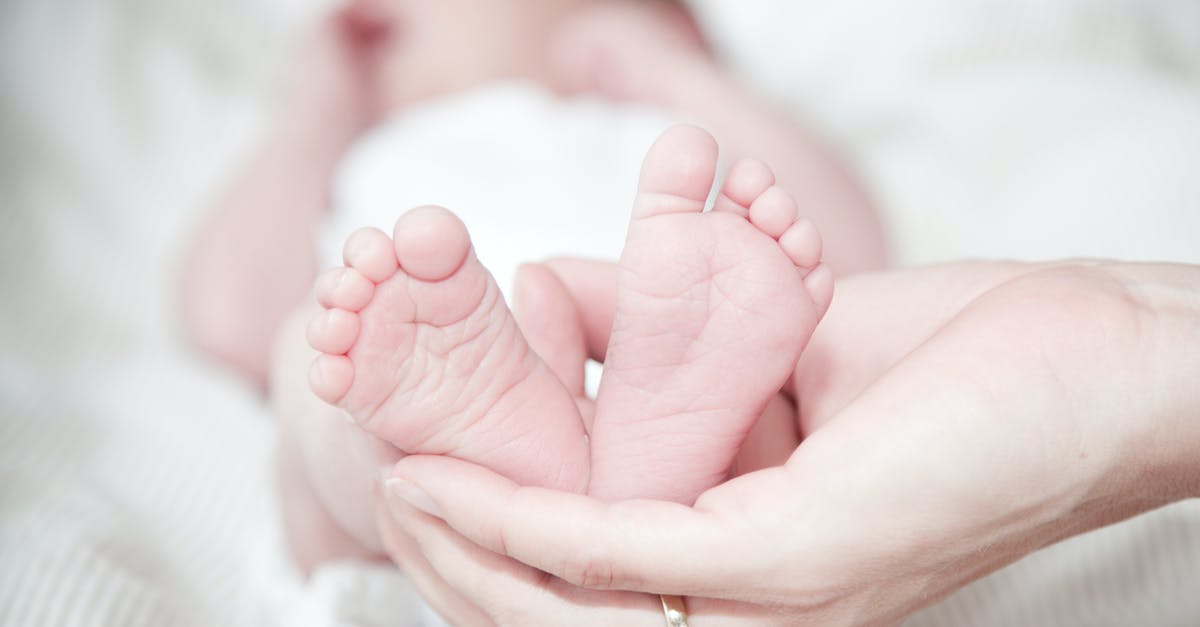 Why don't my female dwellers give birth to children? - Close-up of Hands Holding Baby Feet