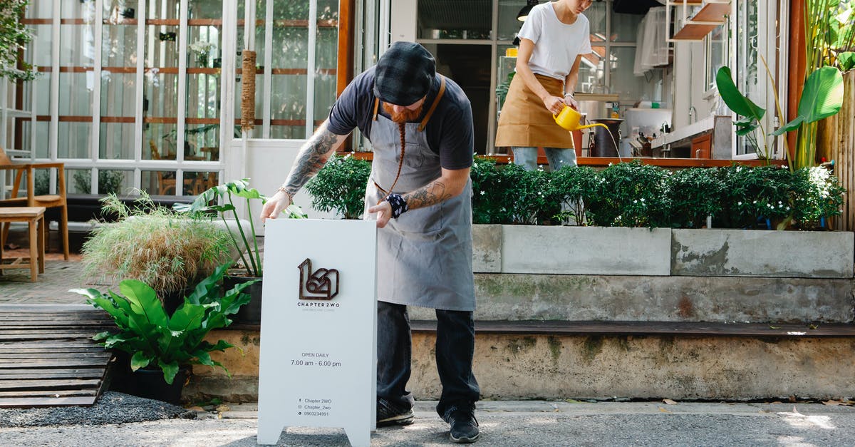 Why i can't put DA:I In English? [duplicate] - Couple of coworkers in aprons and casual clothes watering plants and putting signboard near cafeteria in daytime