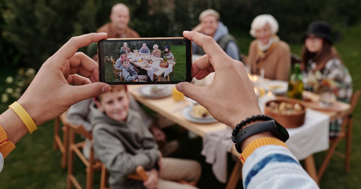 Why is Zekrom easier to capture than Kyurem? - Unrecognizable person taking photo of family dinner on smartphone