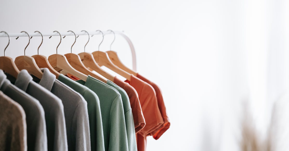 Why won't this wall break? - Interior of light apartment with different clothes on wooden hangers in wardrobe near white walls