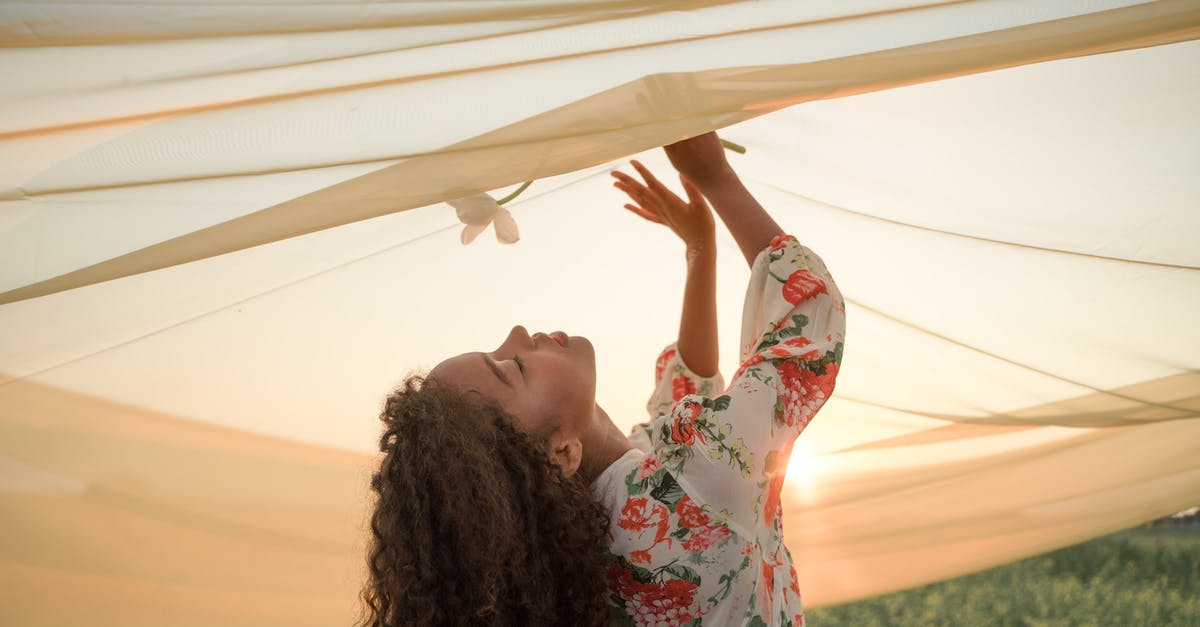 Will a pick last just as long if used under water? - Woman with Long Wavy Hair Smelling White Flower under Transparent Fabric Outspread Above