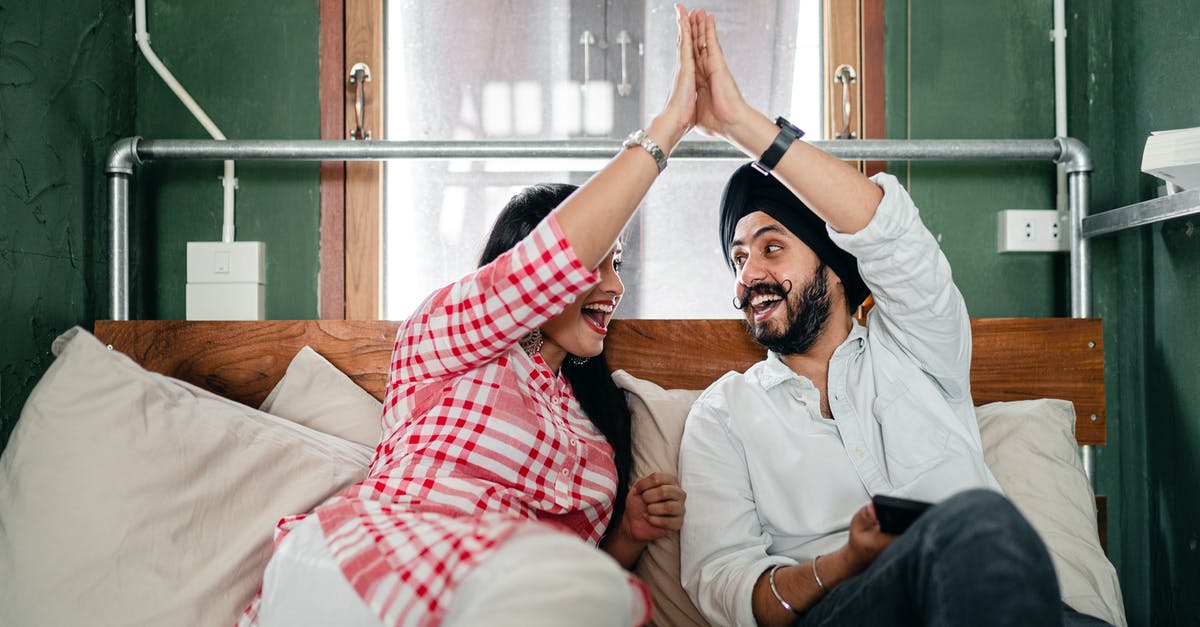 Will searching my dusty bones only give me pieces I don't have? - Positive adult ethnic couple in casual clothes giving high five to each other while resting on bed in small bedroom with sticking out pipe Will searching my dusty bones only give me pieces I don't have? - Positive adult ethnic couple in casual clothes giving high five to each other while resting on bed in small bedroom with sticking out pipe