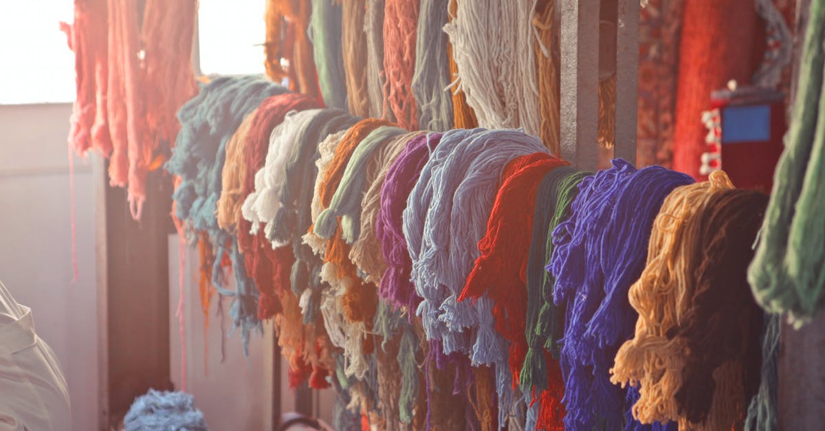 Workshop - not producing anything at all - Skeins of multicolored threads for needlework hanging on wooden rack in light workroom